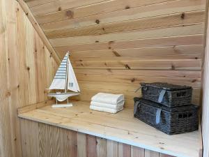 a sauna with a toy sailboat and towels at Sandy Meadow Escapes in Lairg