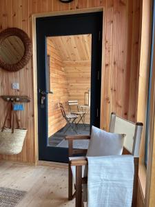 a door into a room with a table and a chair at Sandy Meadow Escapes in Lairg