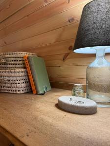 a lamp sitting on top of a table with a book at Sandy Meadow Escapes in Lairg