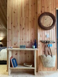 a room with a wooden wall with a shelf and a mirror at Sandy Meadow Escapes in Lairg