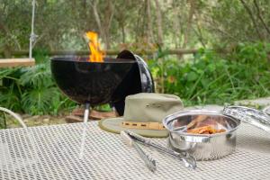 a table with a bowl of food and a grill at Mountain View and Vineyard View in Suider-Paarl