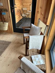 a living room with a chair and a table at Sandy Meadow Escapes in Lairg