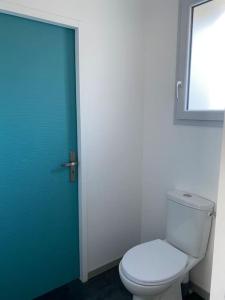 a bathroom with a toilet and a blue door at Grand T2 indépendant centre ville 1er étage in Saint-Junien +3 photos