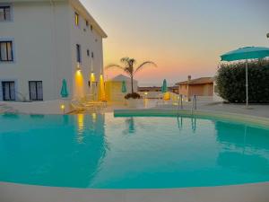 a large swimming pool in front of a building at Best Western Hotel Blumarea in Castelsardo