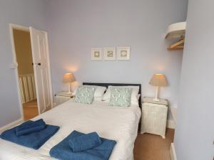 a bedroom with a bed with blue towels on it at Seacliff Cottage in Whitby
