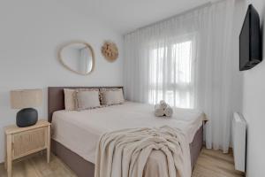 a white bedroom with a bed and a mirror at Apartment Laura Residence Bali in Alicante +19 photos