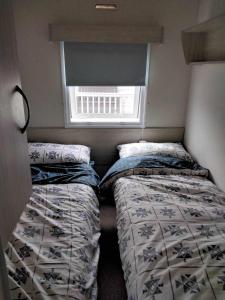 two beds in a small room with a window at 20 Cherry Tree Walk Lyons Robin Hood in in Rhyl