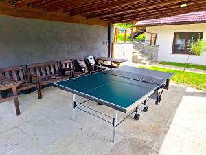 a ping pong table on a patio with benches at Srokówka Resort in Dąbrówka