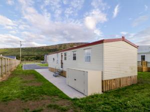 a mobile home in a yard with a fence at Meric Stone Holiday lets Caravan 1 in Castlerock