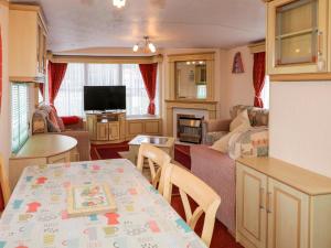 a caravan dining room and living room with a table at Meric Stone Holiday lets Caravan 1 in Castlerock