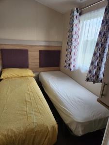 Ένα ή περισσότερα κρεβάτια σε δωμάτιο στο Family Fun by the Sea 4 Bedroom Caravan +12 φωτογραφίες