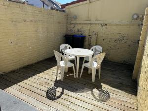 un tavolo bianco e 4 sedie su un patio di Gite maison cosy sur Grand-Fort-Philippe a Grand-Fort-Philippe