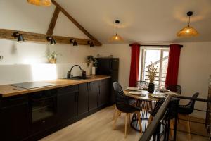 a kitchen with a table and a sink and a table and chairs at La Halte de la tour in Warcq