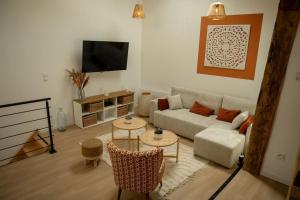 a living room with a couch and a tv at La Halte de la tour in Warcq