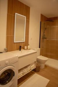 a bathroom with a washing machine and a toilet at La Halte de la tour in Warcq