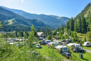 a group of vehicles parked in a field in the mountains at Campingplatz Mauterndorf in Mauterndorf