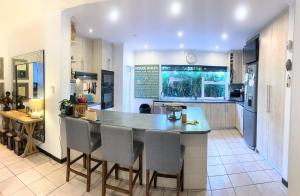 a kitchen with an island with chairs and an aquarium at Regent Casa's - Cape Towns Blouberg Area - Where 20 people can stay in Cape Town