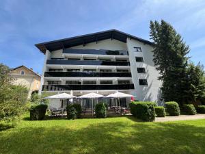 un grande edificio con tavoli e ombrelloni in un cortile di Schinagl Klaus a Klaus an der Pyhrnbahn