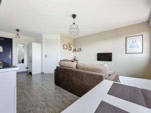 a living room with a couch and a television at Beau duplex et studio proche de la mer in Donville-les-Bains