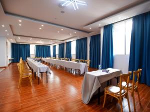 亚的斯亚贝巴Vibes Hotel and Spa的宴会厅配有桌椅和蓝色窗帘