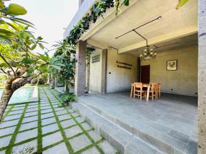 a patio of a house with a table and chairs at Cozy room J in Uluwatu near beach,by d'ulu villa in Uluwatu