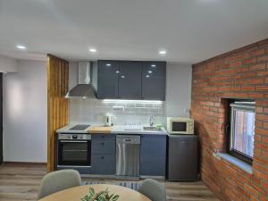 a kitchen with blue appliances and a brick wall at Casa Velha in Linhares