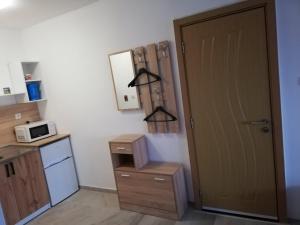 a kitchen with a door and a microwave at Ахтопол студио Ралица in Ahtopol