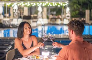 a man and a woman sitting at a table with wine glasses at Bluesun Hotel Borak in Bol