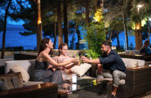 a group of people sitting around a table drinking wine at Bluesun Hotel Borak in Bol