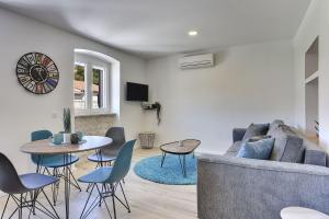 a living room with a couch and a table and chairs at Nur 200 Meter zum Strand mit Salzwasserpool, Fahrräder, Sonnenterrasse in Pula