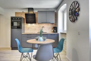 a kitchen with a table and blue chairs at Nur 200 Meter zum Strand mit Salzwasserpool, Fahrräder, Sonnenterrasse in Pula +5 photos