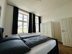una camera da letto con un letto e due finestre di Moderne Ferienwohnung inmitten der Altstadt a Schwerin