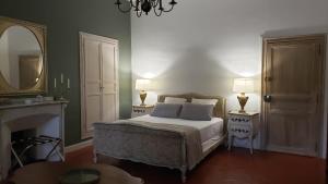 a bedroom with a bed with two lamps and a mirror at Maison NOLIA - Espaces dédiés in Fabrezan