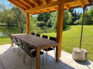 a wooden pergola with a wooden table and chairs at W-Apartments - Spacious Parking, EV-Station & Private Outdoor Area with Playground in Offenburg