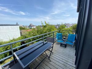 een terras met twee stoelen en een bank op een balkon bij Ty Fanch Quiberon in Quiberon