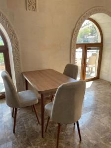 a wooden table and chairs in a room with windows at Nemrut Çesme Otel Restaurant Cafe in Adıyaman +25 photos