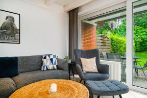 a living room with a couch and chairs and a table at Ferienhaus Heimathafen in Bensersiel