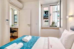 ein Schlafzimmer mit einem Bett mit Handtüchern darauf in der Unterkunft InLoveApartments - Luxury in Alfama in Lissabon