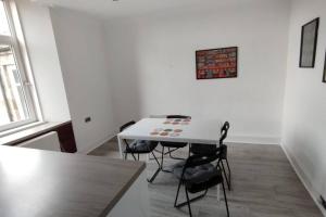 a small white table with chairs in a room at Lovely flat near Glasgow in Barrhead