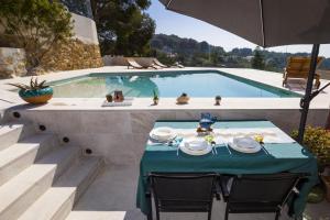 ein Tisch mit Tellern voller Essen neben einem Swimmingpool in der Unterkunft Mora Villa ONLY FAMILIES in Tarragona + 47 Fotos