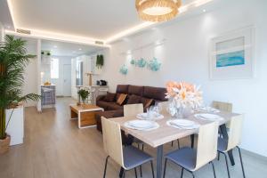 a dining room and living room with a table and chairs at La Palapa Beach in Benalmadena Costa