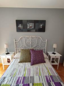 a bedroom with a bed with two tables and two lamps at Acogedor Apartamento En Huesca in Huesca