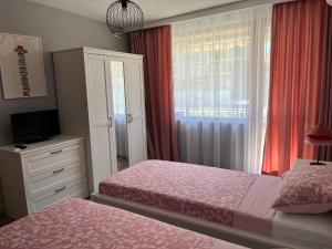 a bedroom with two beds and a dresser and a window at Одеса 37 in Sozopol