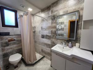 a bathroom with a sink and a toilet and a mirror at Одеса 37 in Sozopol