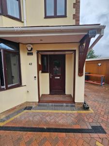 a house with a brown door on a brick sidewalk at Shortwood Stay in Staines upon Thames