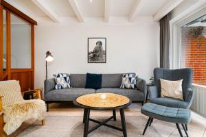 a living room with a couch and a table and chairs at Ferienhaus Heimathafen in Bensersiel