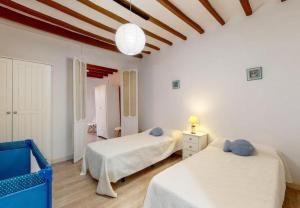 two beds in a room with white walls and wooden floors at Ibicenco Villajoyosa in Villajoyosa