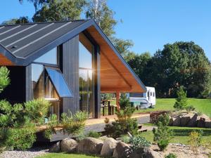 博伊恩斯多夫Werder Chalet -- L I E G E P L A T Z -- Ostsee Strand 150m I Sauna I eKamin I Ferienhaus an Ostsee bis 8 Pers I by "Meyers am Meer"的一栋黑色屋顶的小房子