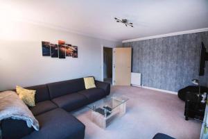 a living room with a couch and a table at Inverurie Town Centre 97m2 Maisonette in Inverurie