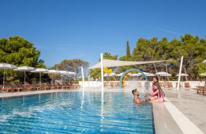 two girls playing in the pool at a resort at Bluesun Holiday Village Bonaca - Full Board Plus in Bol